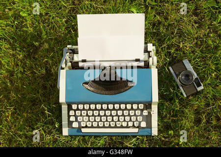 Typewriter and old camera on Grass Stock Photo