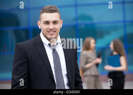 Portrait of confident young business man looking at camera with happy facial expression outdoors. Successful attractive Stock Photo