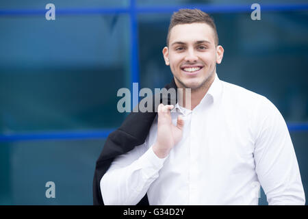 Portrait of confident young business man looking at camera with happy facial expression outdoors Stock Photo