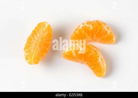 three separated segments of tangerine on white background Stock Photo