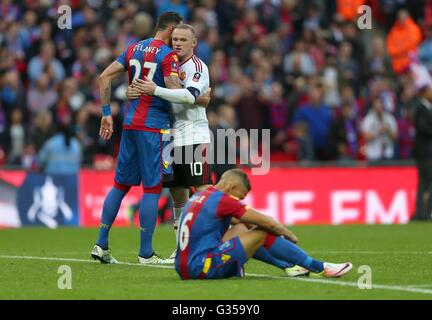 Crystal Palace’s Dwight Gayle looks dejected as Wayne Rooney of Manchester United consoles Crystal Palace’s Damien Delaney during the Emirates FA Cup Final between Crystal Palace and Manchester United at Wembley Stadium in London. May 21, 2016.EDITORIAL USE ONLY. No use with unauthorized audio, video, data, fixture lists, club/league logos or 'live' services. Online in-match use limited to 75 images, no video emulation. No use in betting, games or single club/league/player publications. James Boardman / Telephoto Images +44 7967 642437 Stock Photo