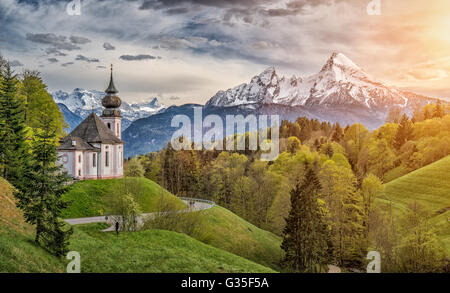 Beautiful mountain landscape in Bavarian Alps with famous pilgrimage church of Maria Gern and Watzmann in golden evening light Stock Photo