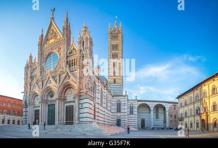 Beautiful panoramic view of famous Piazza del Duomo with historic Siena Cathedral at sunset, Tuscany, Italy Stock Photo