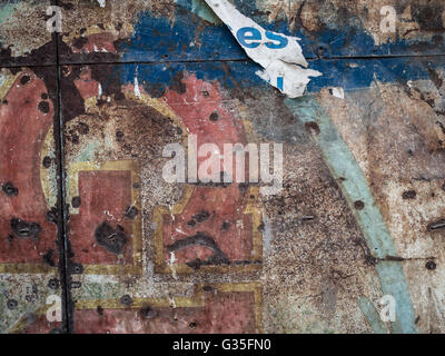 A torn flypost on grungy textured wall Stock Photo