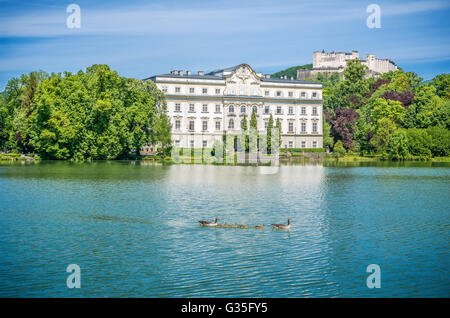 Famous Schloss Leopoldskron with Hohensalzburg Fortress in the background on a sunny day with blue sky in Salzburg, Austria Stock Photo