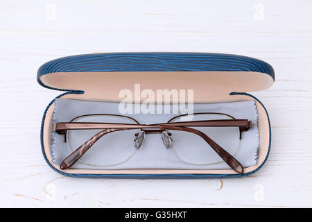 Glasses and case with glasses cleaning cloth on white wooden table Stock Photo