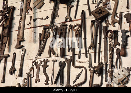 Antique tools hanging on a farm shop wall Stock Photo