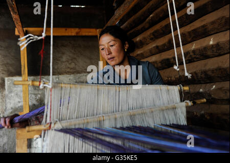 CHINA Yunnan Lugu Lake , ethnic minority Mosuo who are buddhist and women have a matriarch, woman weave at loom in cottage industry , matriarchal society Stock Photo