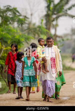 A family walks together in Pan Bari Village in the Kaziranga National Park in India on the 13th April 2016.  Credit: Euan Cherry Stock Photo