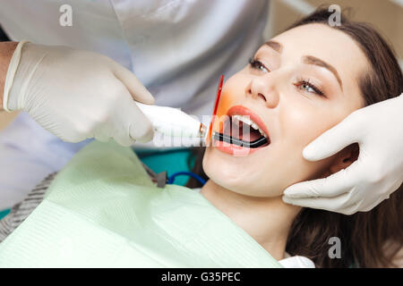 Close-up portrait of a girl getting her teeth bleached in clinic Stock Photo