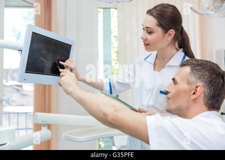 Two concentrated dentists looking at x-ray on computer in clinic Stock Photo