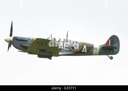 Spitfire flying; Supermarine Spitfire fighter plane in flight, side view, Imperial War Museum, Duxford, UK Stock Photo