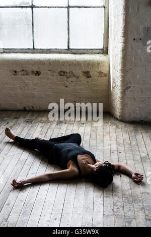 Dead woman's body on the floor by the window Stock Photo