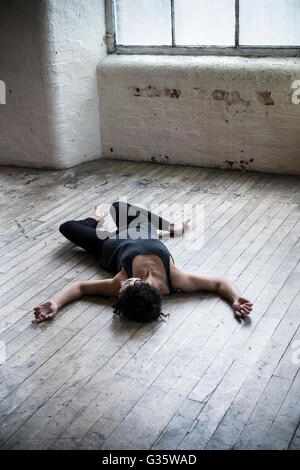 Dead woman's body on the floor by the window Stock Photo