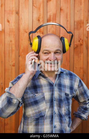 Construction worker in protective headphones during a break talking on the phone Stock Photo