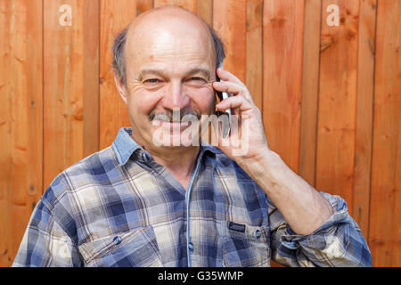 Elderly man talking on the phone. Maintaining family ties at a distance. Order by phone Stock Photo