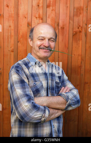 Elderly man crossed his arms over his chest. Pensioner complacently looks forward Stock Photo