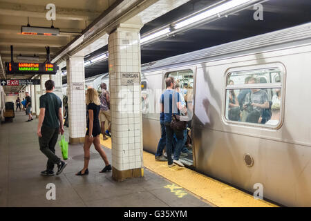 Travelers waiting on the Morgan Avenue 'L' train subway platform in the Bushwick neighborhood of Brooklyn in New York on Saturday, June 4, 2016. The neighborhood has undergone gentrification changing from a rough and tumble mix of Hispanic and industrial to a haven for hipsters, forcing many of the long-time residents out because of rising rents.. (© Richard B. Levine) Stock Photo