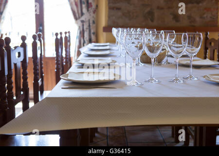 Table ready and waiting for the guests to arrive at a rustic restaurant Stock Photo