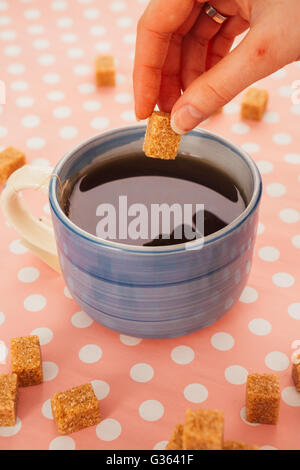 blue cup of tea and lump sugar on pink  background Stock Photo