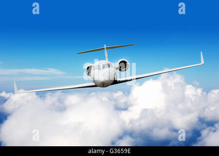 Private jet plane flying above clouds, shot from front view Stock Photo