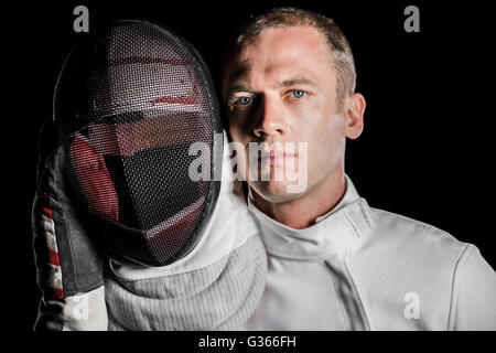 Close-up of swordsman holding fencing mask Stock Photo