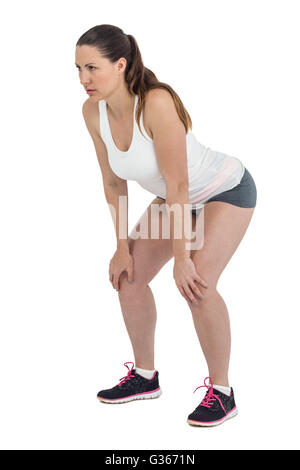 Tired athlete standing with hand on knee Stock Photo