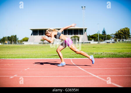 Female athlete running on the racing track Stock Photo