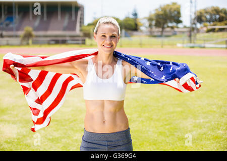 Portrait of female athlete wrapped in american flag Stock Photo