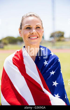 Happy female athlete wrapped in american flag Stock Photo - Alamy