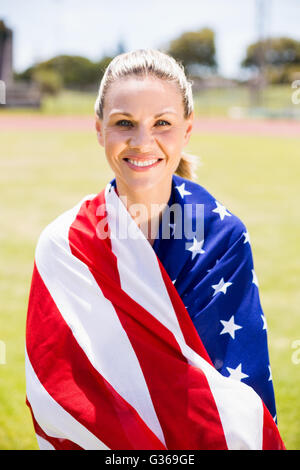 Portrait of female athlete wrapped in american flag Stock Photo