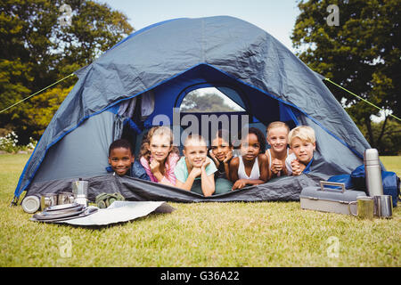 Smiling children lying in the tent together Stock Photo
