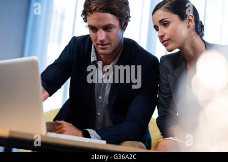 Casual colleagues using laptop Stock Photo