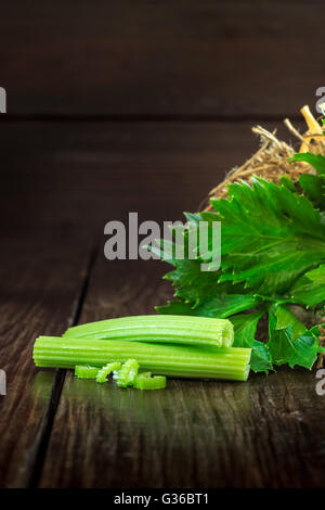Celery leaves and sticks on dark wooden background. Copy space Stock Photo