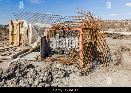 Old Rusty scaffold pipe clamp, mounting parts of scaffolding, placed in metal pallet on construction site. Stock Photo