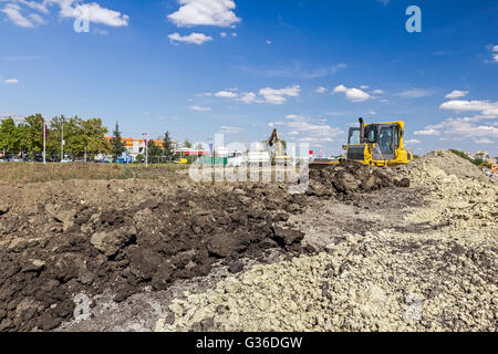 Earthmover with caterpillar is moving earth outdoors. Stock Photo