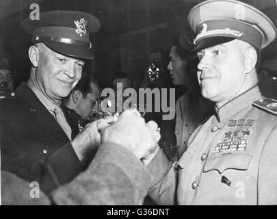 Allied leaders, Supreme Commander General Dwight Eisenhower (left), Soviet Marshal Zhukov (right), and British General Montgomery (unseen left), toast the Allied victory. Stock Photo