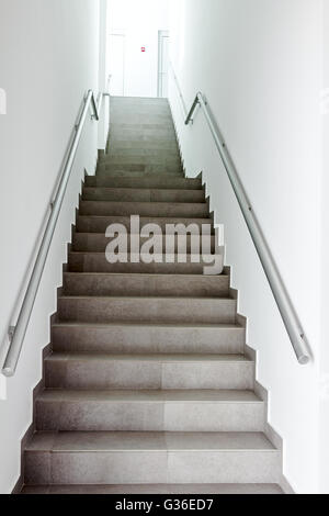 Stairway with metallic banister in a new modern building. Every building is required to have emergency stairways as safety measu Stock Photo