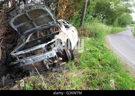 Burnt out car wreck in a ditch near Ashcott in rural Somerset, 8th June 2016 Stock Photo