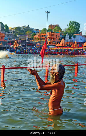 A Hindu holy man offers prayers to the Sun after taking a holy dip, Kumbh Mela, Ujjain, Madhya Pradesh, India - 2016 Stock Photo