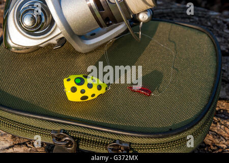 Close up view of fishing reel with fishing bait on the natural background. Objects on the green box for fishing bait on the old Stock Photo