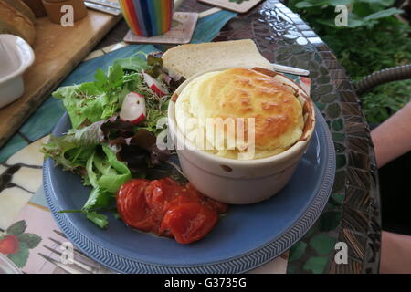 Cheese souffle with roasted tomatoes and a garden salad Stock Photo