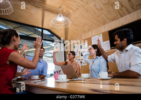 Casual colleagues doing high-five Stock Photo