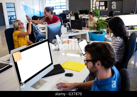 Casual colleagues giving high-five Stock Photo