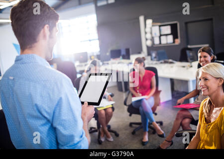 Casual businessman giving a speech to his colleagues Stock Photo