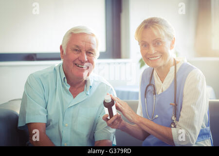 Female doctor giving medicine to senior man Stock Photo