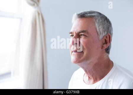 Thoughtful senior man in bedroom Stock Photo