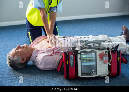 Paramedic using an external defibrillator during cardiopulmonary resuscitation Stock Photo