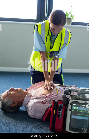 Paramedic using an external defibrillator during cardiopulmonary resuscitation Stock Photo