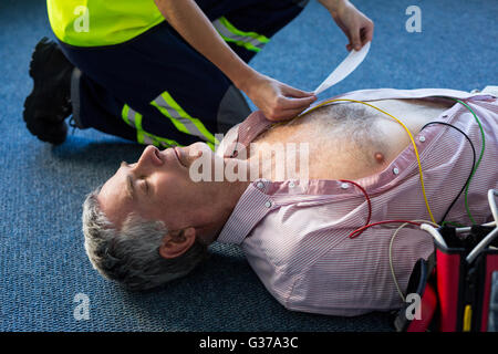 Paramedic using an external defibrillator during cardiopulmonary resuscitation Stock Photo